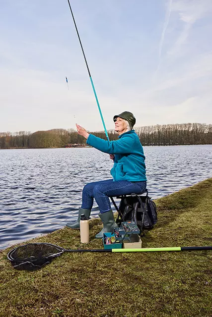 Oudere vrouw die zit te vissen